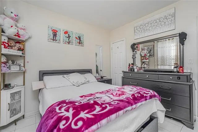 a bedroom with a bed and a flat tv screen on the dresser
