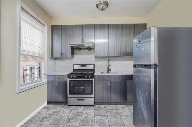 a kitchen with stainless steel appliances a refrigerator and a stove