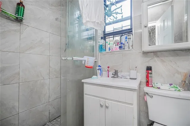 a bathroom with a sink vanity and a shower