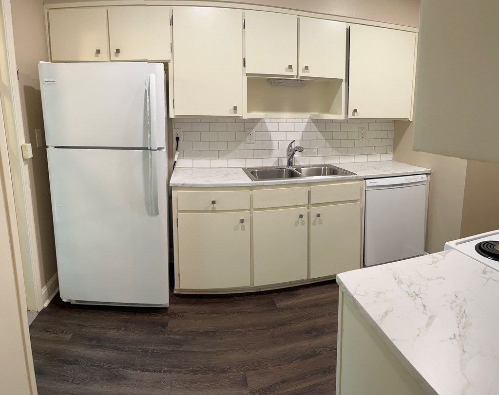 2312 15th Street, Unit A Columbus, GA 31906 - Photo 11 of 20 a kitchen with a sink a refrigerator and white cabinets