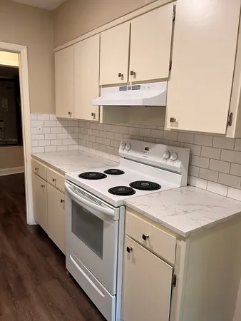 a kitchen with granite countertop white cabinets and white appliances