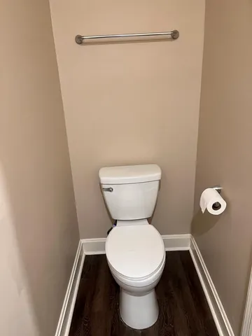 a white toilet sitting next to a shower