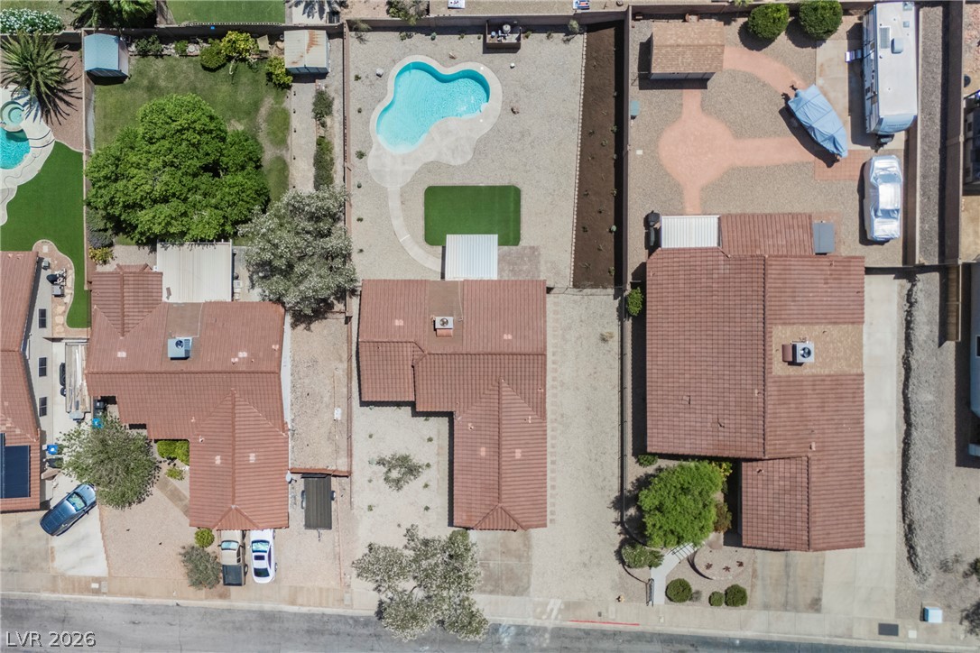 112 Iridescent Street Henderson, NV 89012 - Photo 22 of 24 An aerial perspective showcases three homes, revealing the intricate layout of each property and its surrounding landscape.
