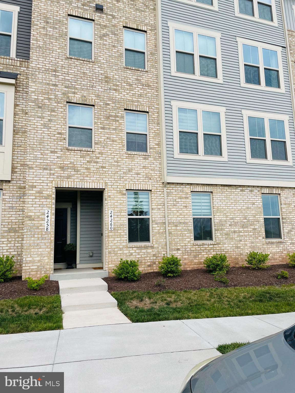 a view of a brick building with many windows and plants