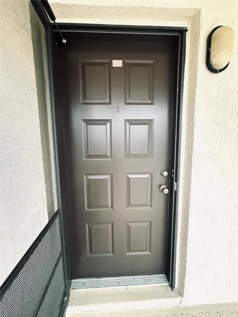 a front view of a house with a yard and potted plants