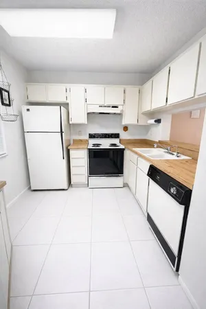 a kitchen with stainless steel appliances a stove a sink and white cabinets