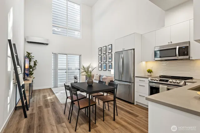 a kitchen with stainless steel appliances a stove a refrigerator and a dining table