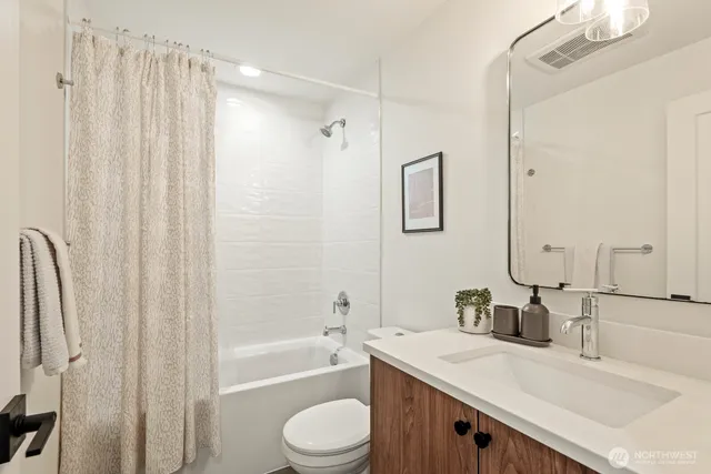 a bathroom with a granite countertop sink a toilet and shower