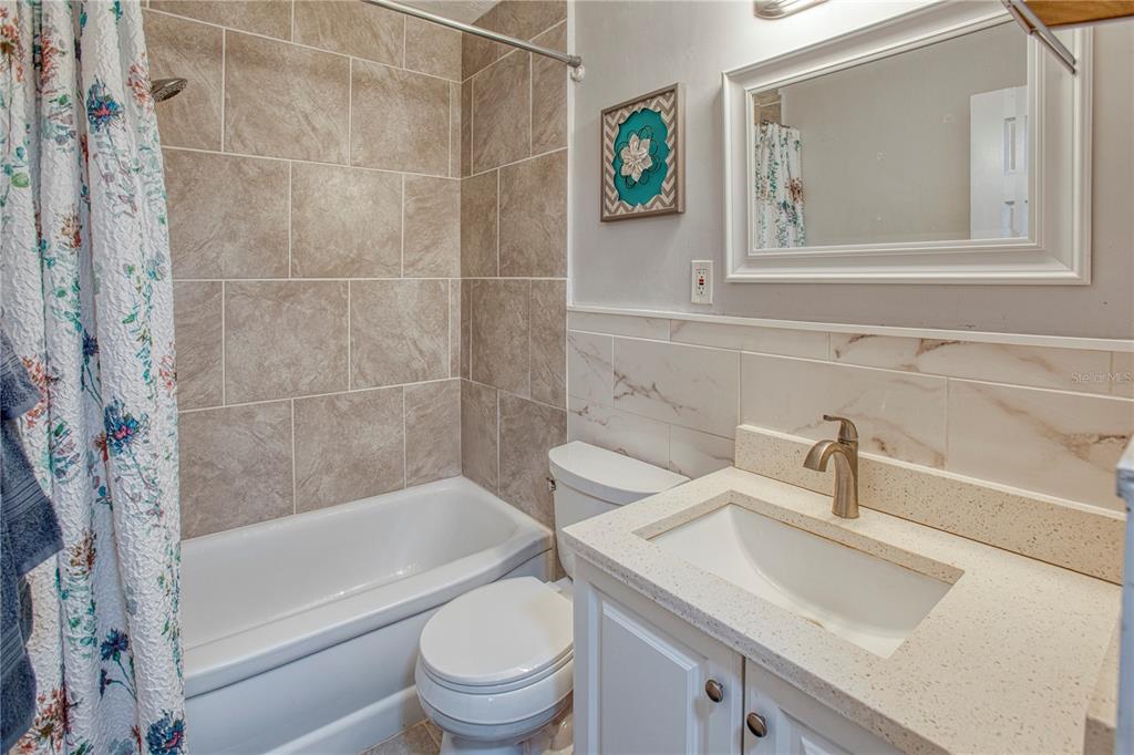 4001 58th Street North, Unit 3 Kenneth City, FL 33709 - Photo 4 of 12 a bathroom with a sink a toilet and shower