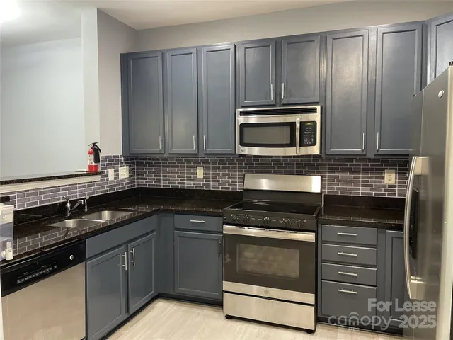 a kitchen with granite countertop wooden cabinets and stainless steel appliances