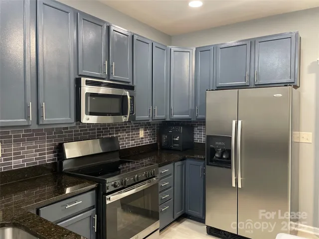 a kitchen with granite countertop stainless steel appliances and wooden cabinets