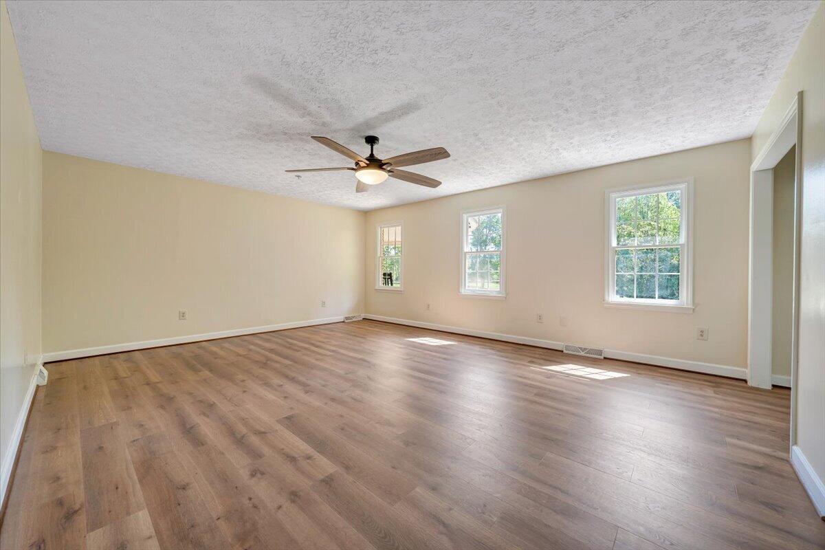 2011 Spencer-Preston Road Martinsville, VA 24112 - Photo 50 of 130 an empty room with wooden floor chandelier fan and windows