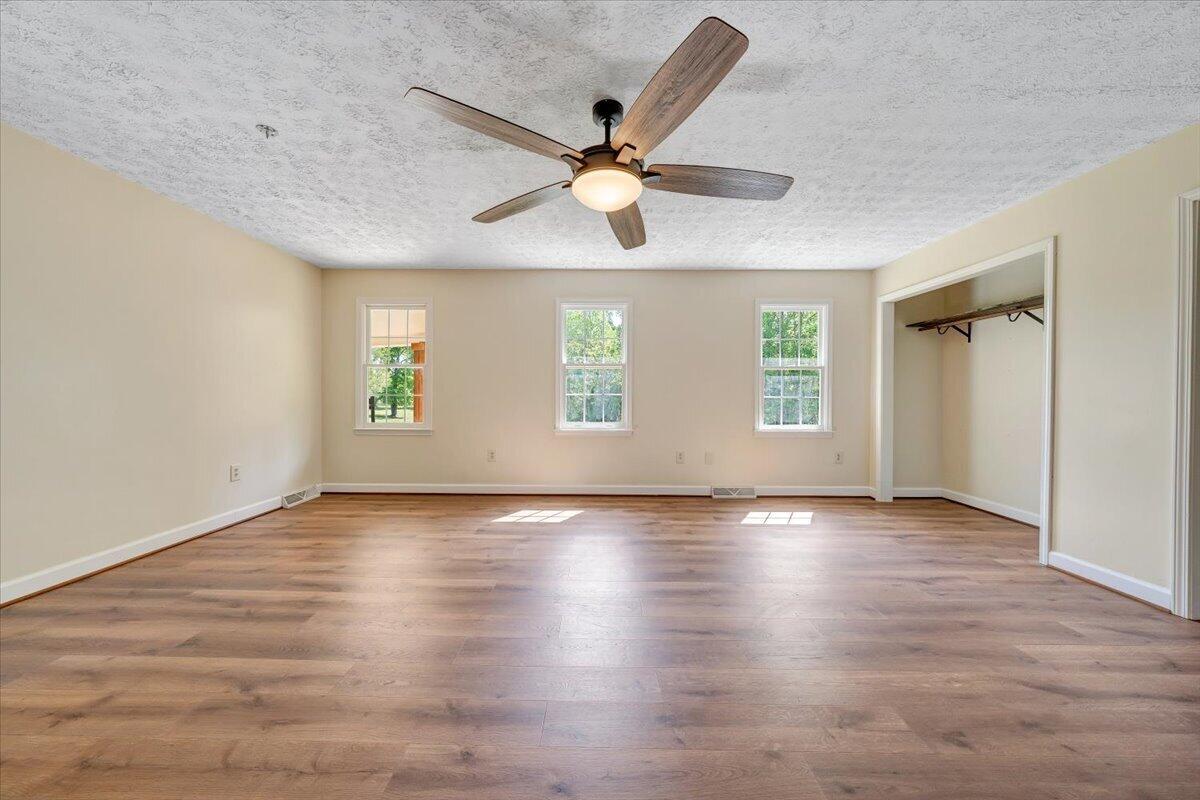 2011 Spencer-Preston Road Martinsville, VA 24112 - Photo 51 of 130 an empty room with wooden floor fan and windows