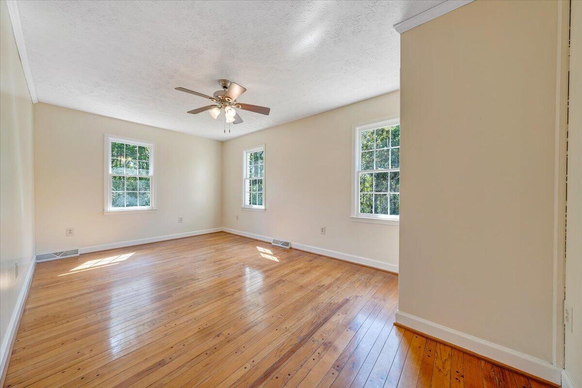 2011 Spencer-Preston Road Martinsville, VA 24112 - Photo 56 of 130 an empty room with wooden floor ceiling fan and windows