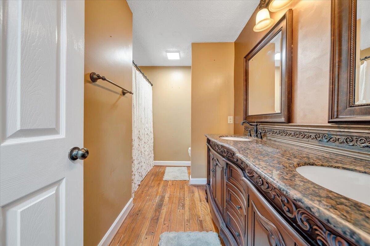 2011 Spencer-Preston Road Martinsville, VA 24112 - Photo 60 of 130 a bathroom with a granite countertop sink a mirror and a shower