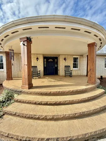a view of a hallway with wooden floor and a bathroom
