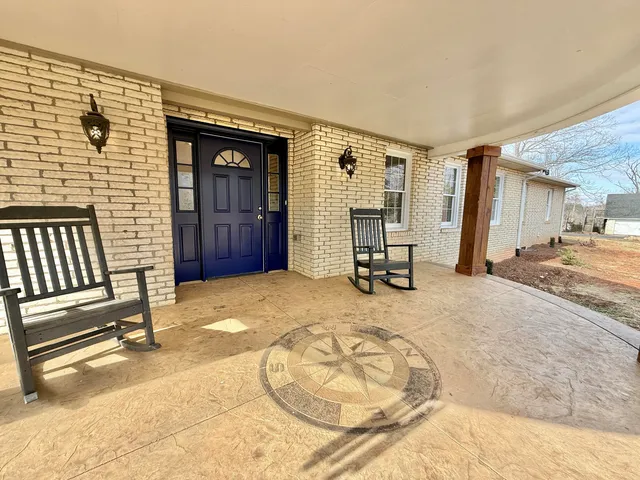 an empty room with wooden floor a ceiling fan and staircase