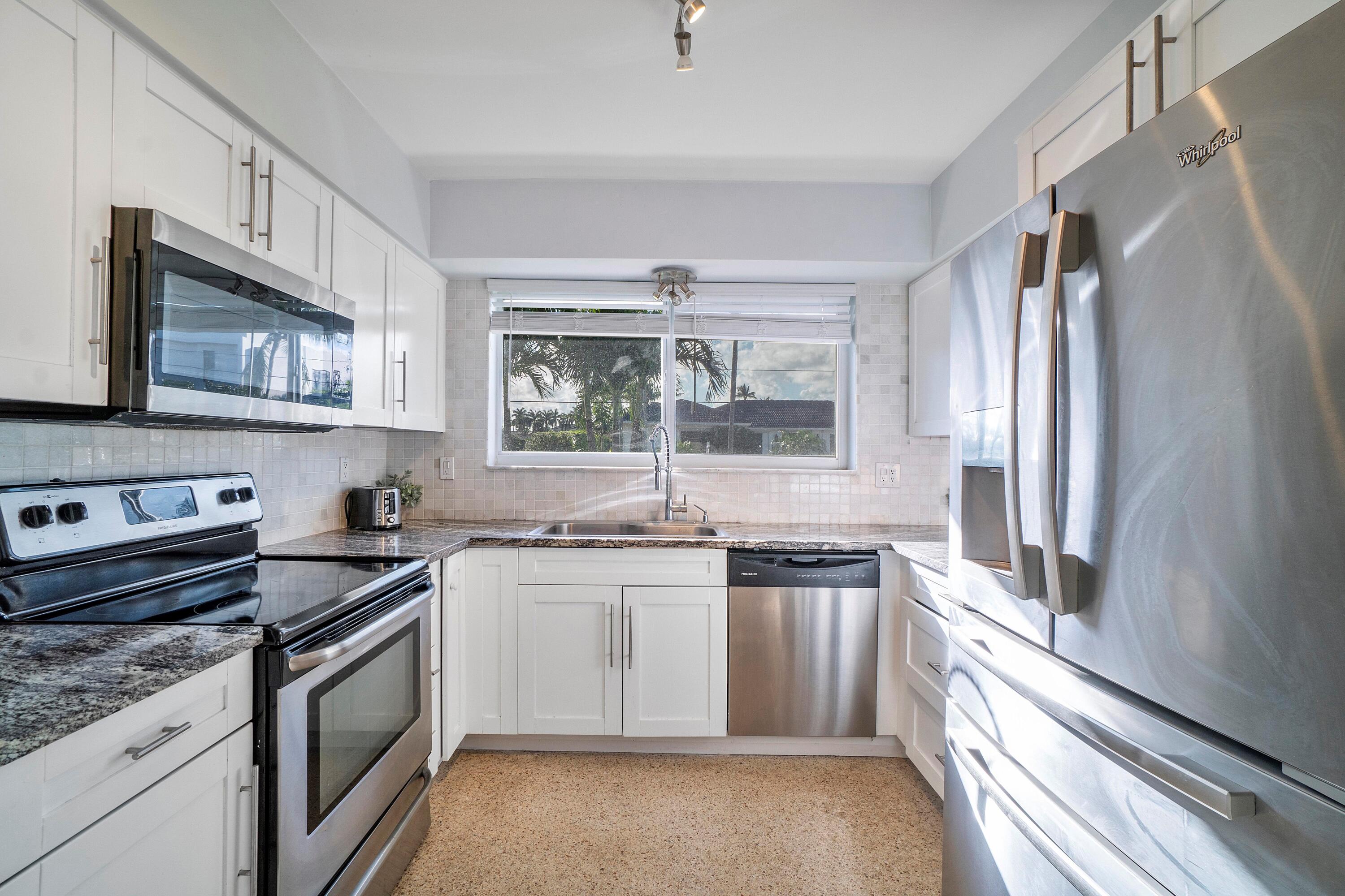 2900 Spanish River Road Boca Raton, FL 33432 - Photo 15 of 25 a kitchen with stainless steel appliances granite countertop a stove a sink and a refrigerator