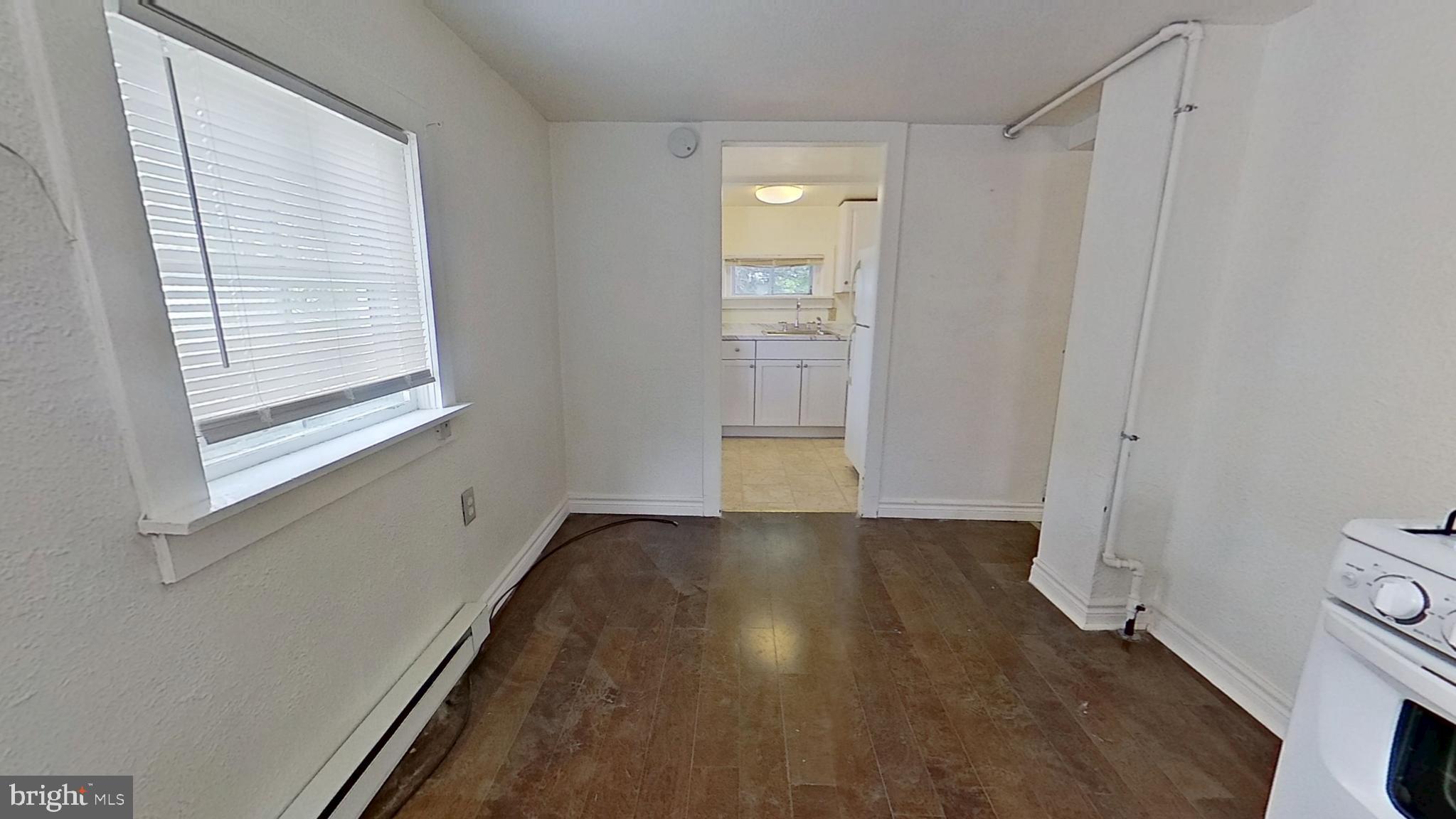 28 East Maple Street Dallastown, PA 17313 - Photo 2 of 6 a view of an empty room with a window and wooden floor
