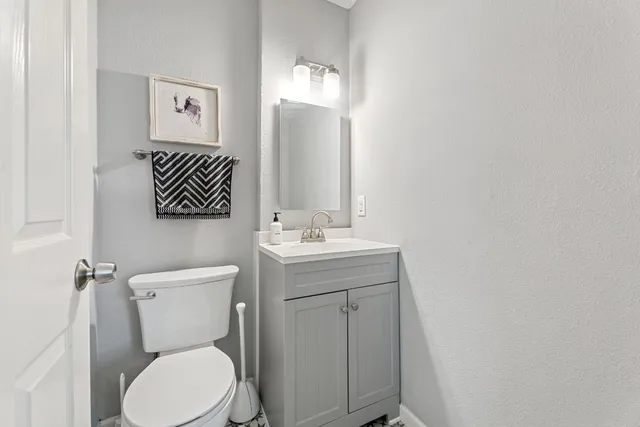 a bathroom with a toilet a sink and mirror