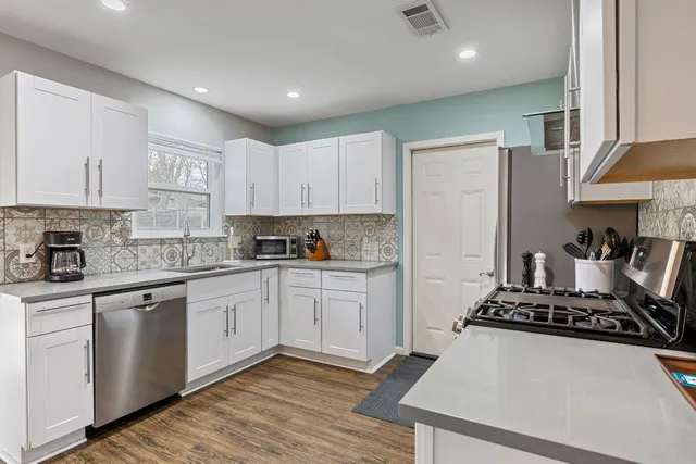 a kitchen with stainless steel appliances granite countertop a stove and a refrigerator