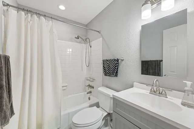 a bathroom with a sink toilet a mirror and shower