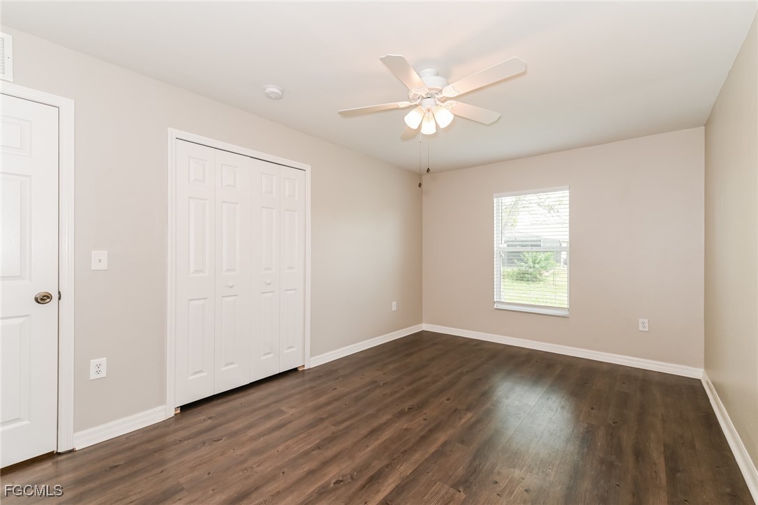 9091 Morris Road Fort Myers, FL 33967 - Photo 12 of 15 an empty room with wooden floor fan and windows