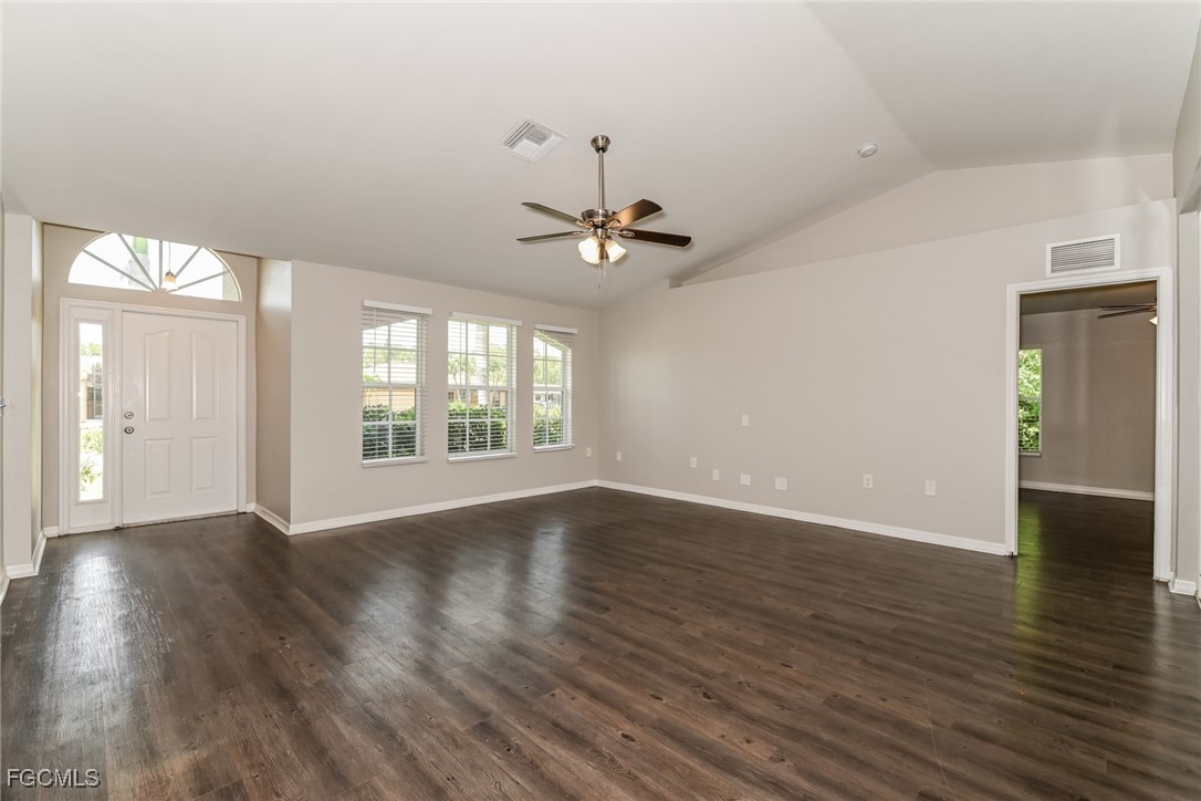 9091 Morris Road Fort Myers, FL 33967 - Photo 3 of 15 an empty room with wooden floor and windows