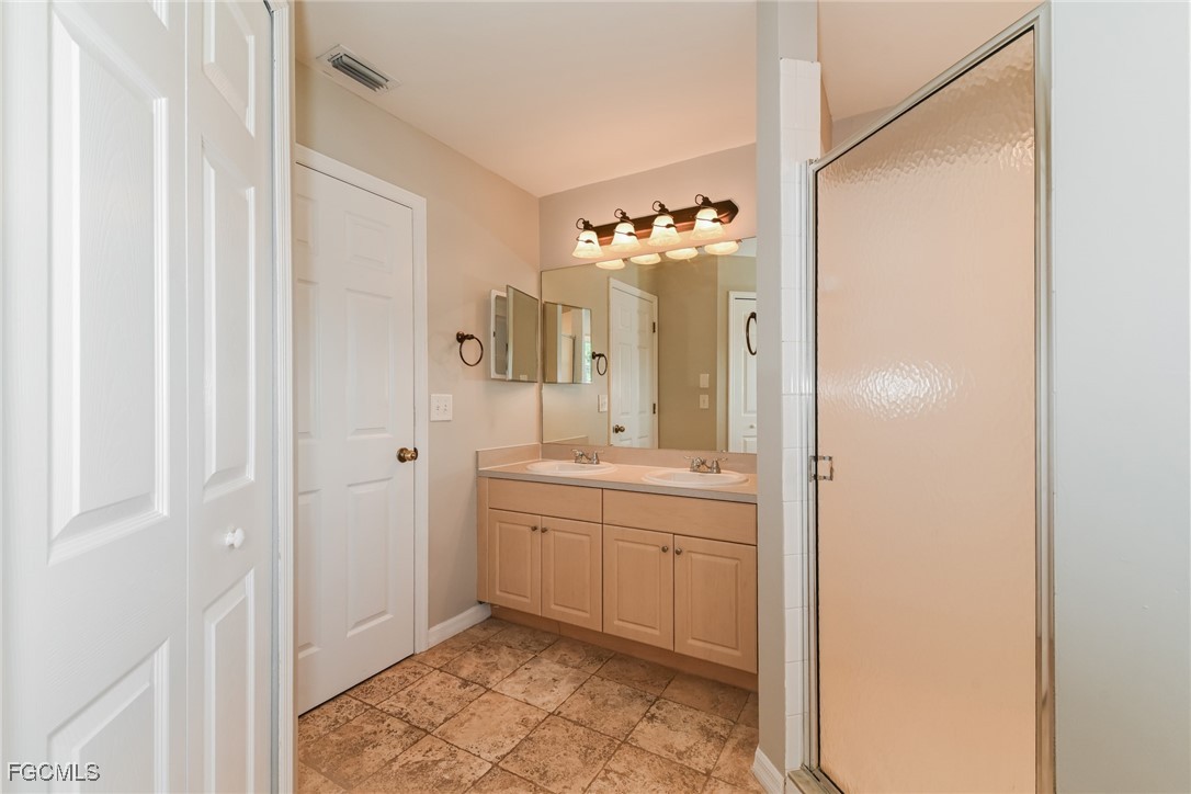 9091 Morris Road Fort Myers, FL 33967 - Photo 10 of 15 a spacious bathroom with a double vanity sink a mirror and a shower