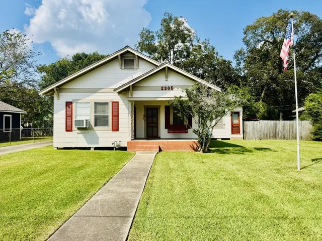 a view of a house with a yard and chairs