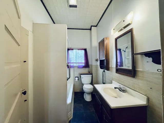 a bathroom with a sink mirror and toilet