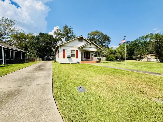 a front view of a house with a yard and trees