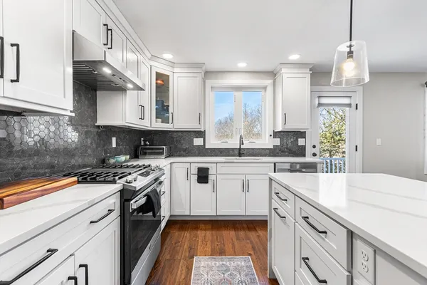 a kitchen with stainless steel appliances granite countertop a sink stove and cabinets