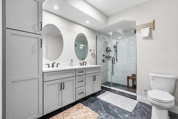 a bathroom with a double vanity sink toilet and shower