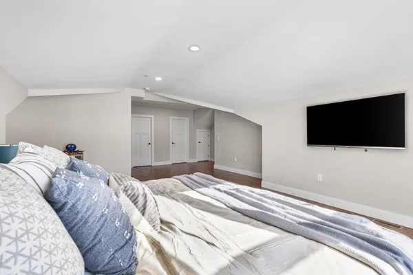 a bedroom with a flat screen tv and a bed