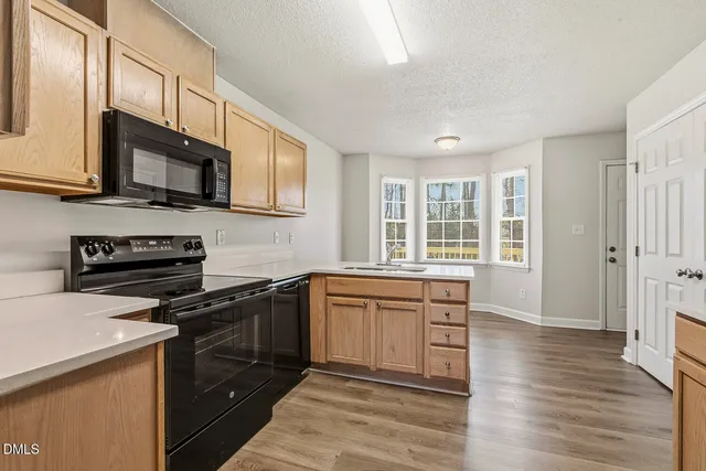 a kitchen with stainless steel appliances granite countertop wooden cabinets and a stove top oven