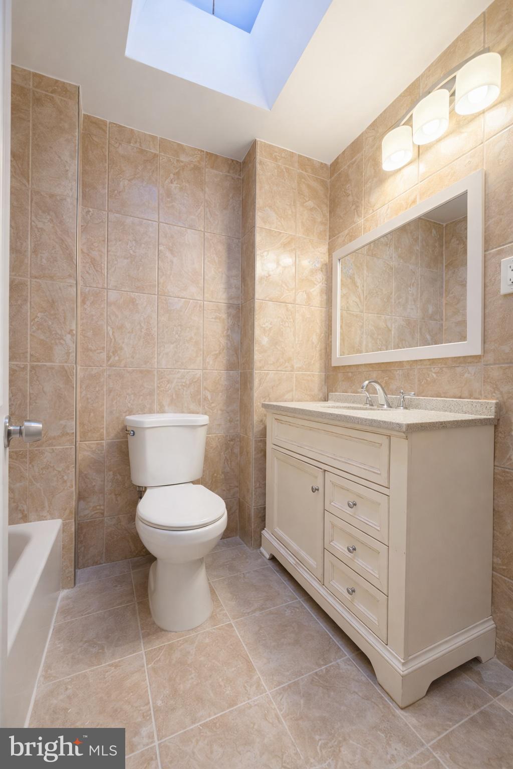 419 Rennard Street Philadelphia, PA 19116 - Photo 11 of 15 a bathroom with a toilet a sink and mirror