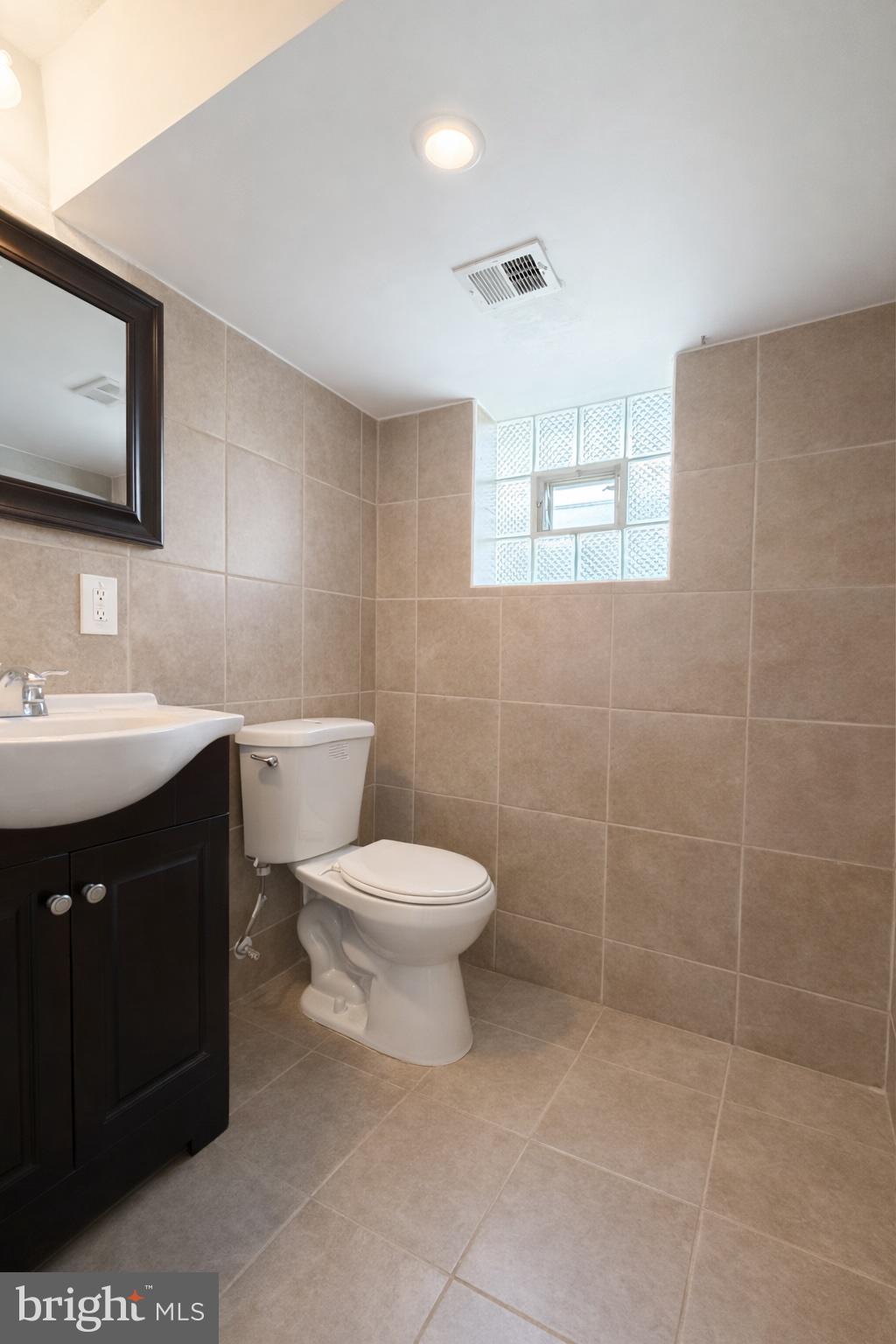 419 Rennard Street Philadelphia, PA 19116 - Photo 15 of 15 a bathroom with a sink a toilet and mirror