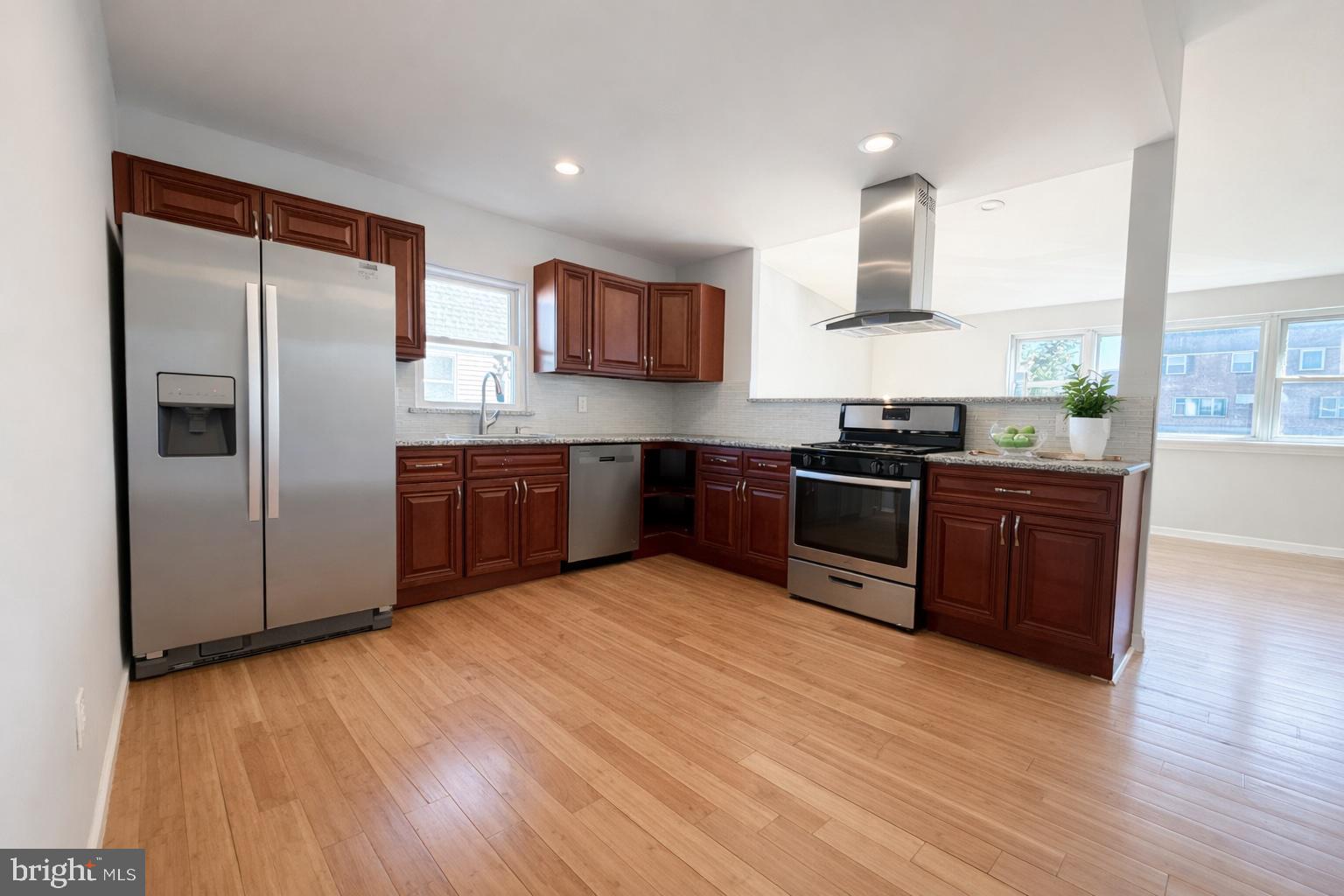 419 Rennard Street Philadelphia, PA 19116 - Photo 3 of 15 a kitchen with stainless steel appliances granite countertop a refrigerator a sink dishwasher a stove with wooden cabinets and floor