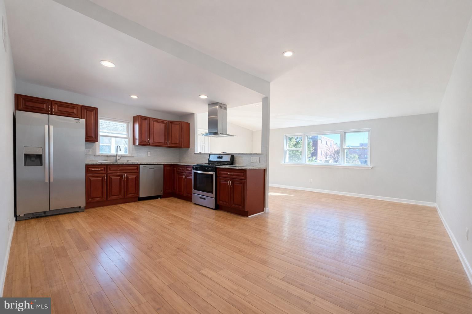 419 Rennard Street Philadelphia, PA 19116 - Photo 4 of 15 a large kitchen with stainless steel appliances wooden floors and wooden cabinets