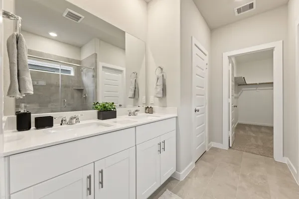 a bathroom with a double vanity sink mirror and shower