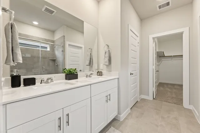 a bathroom with a double vanity sink mirror and shower