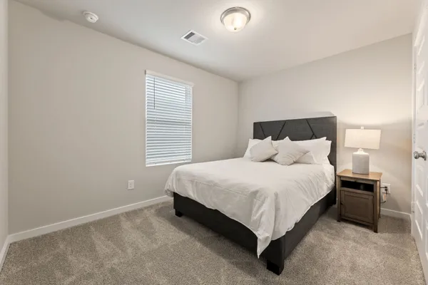 a bed sitting in a bedroom next to a window