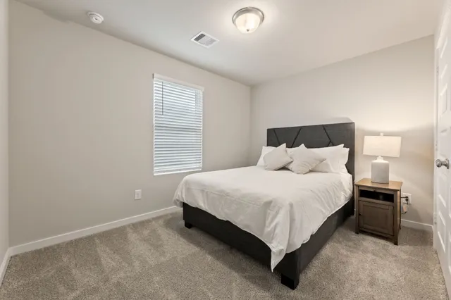 a bed sitting in a bedroom next to a window