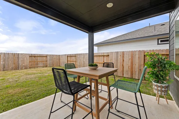 a view of a patio with table and chairs a barbeque with wooden floor and fence