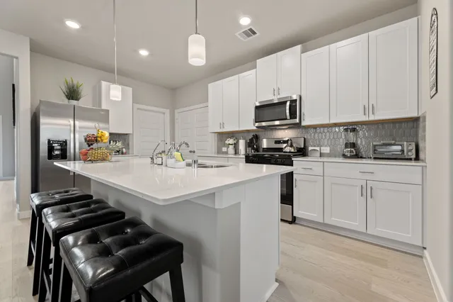 a kitchen with a sink stainless steel appliances and white cabinets