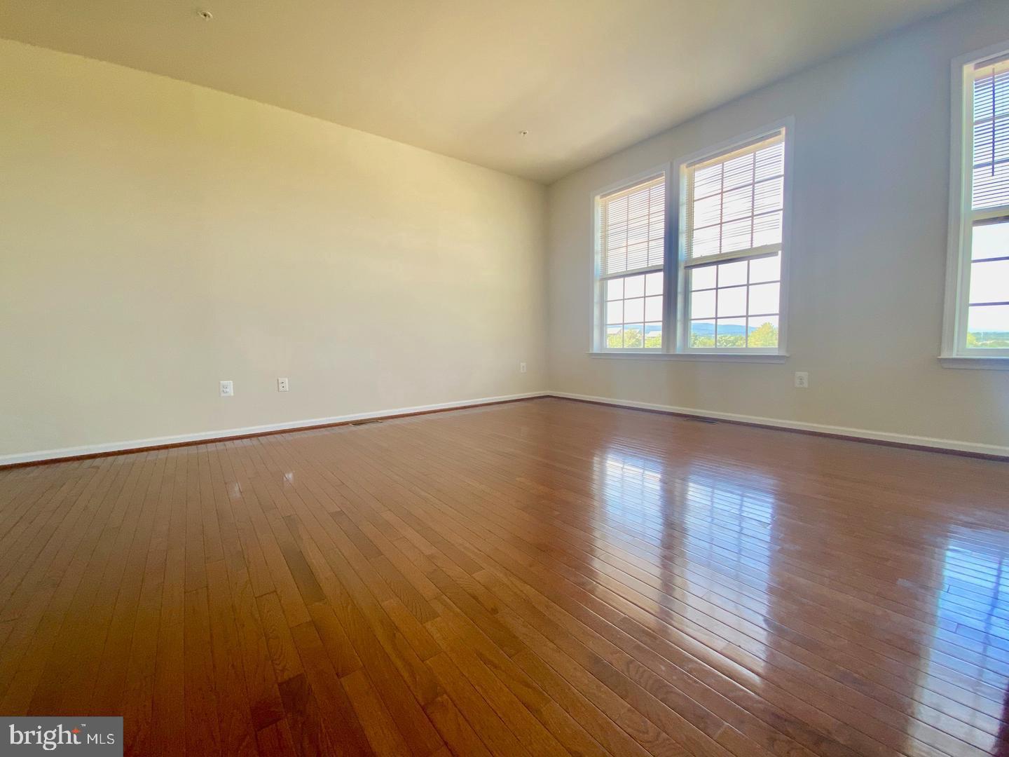 1100 Frontline Drive Frederick, MD 21703 - Photo 8 of 19 an empty room with wooden floor and windows