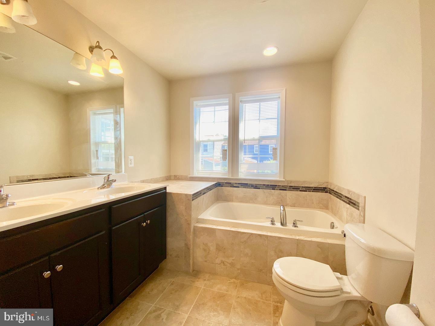 1100 Frontline Drive Frederick, MD 21703 - Photo 10 of 19 a bathroom with a granite countertop sink and a bathtub
