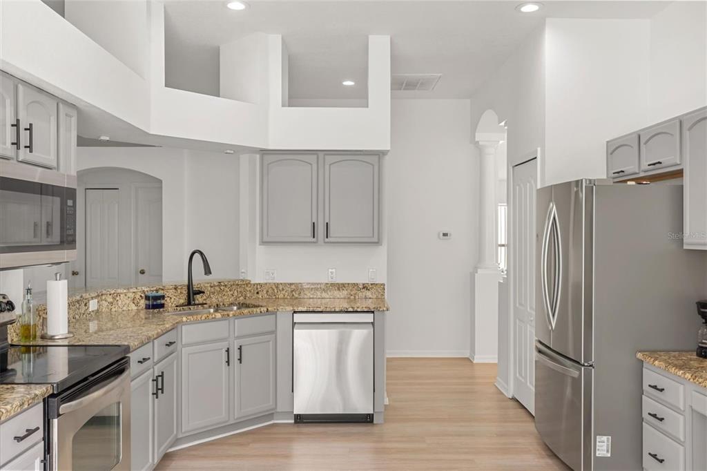 11478 Weston Course Loop Riverview, FL 33579 - Photo 4 of 22 a kitchen that has a refrigerator a sink and white cabinets
