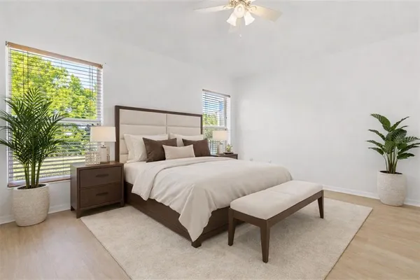a bedroom with a large bed and a potted plant
